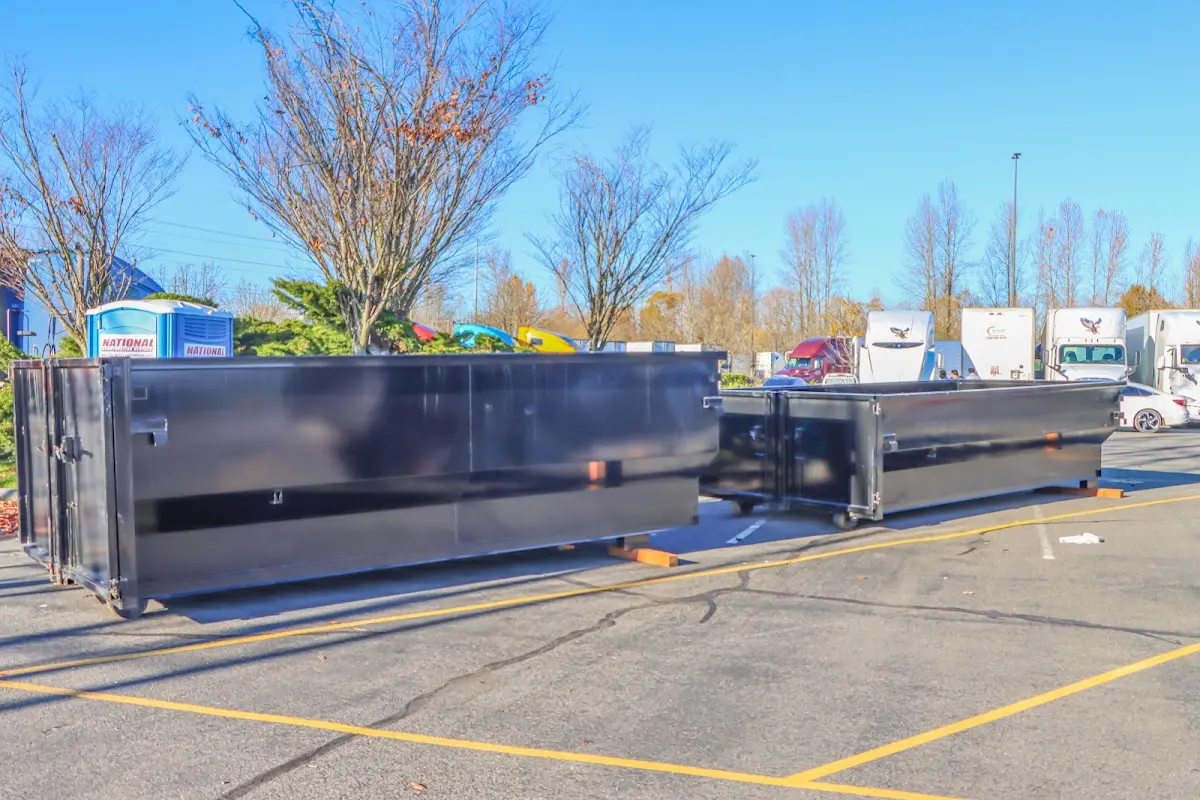 Professional dumpster rental service with roll-off container on residential driveway in Otis Orchards-East Farms